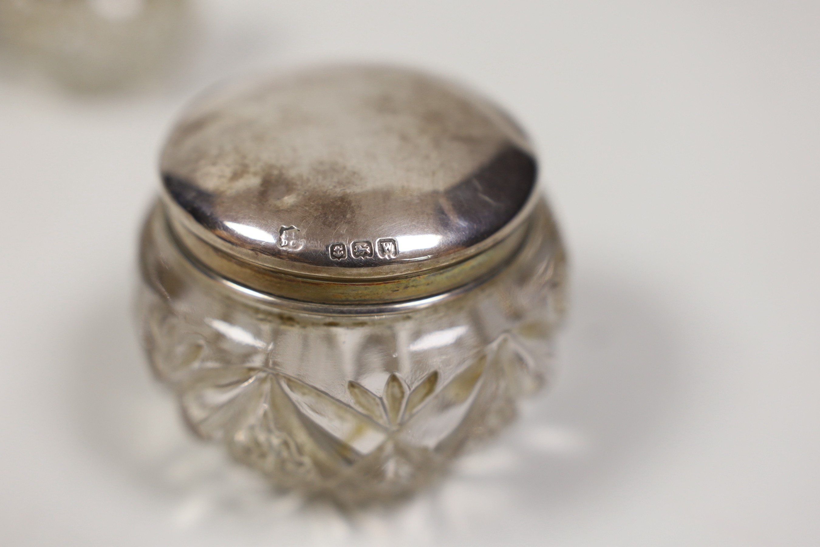 Six assorted small silver mounted glass toilet jars.